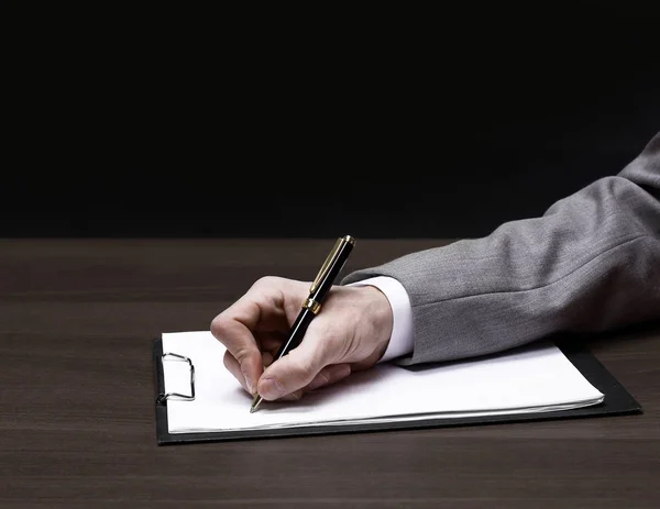 Primer plano. hombre de negocios escribiendo en hoja de papel en blanco . — Foto de Stock