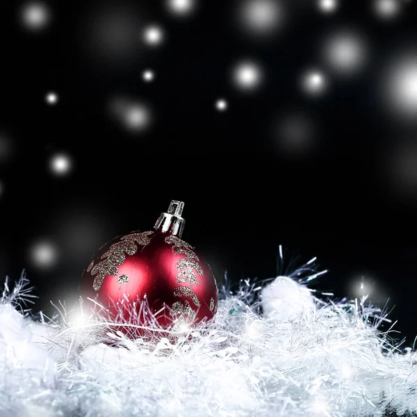 Schöne rote Weihnachtskugel auf schwarzem Hintergrund. — Stockfoto