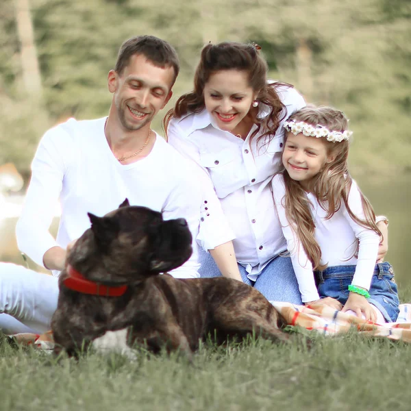 Glückliche Familie mit Hund beim Picknick an einem sonnigen Sommertag. — Stockfoto