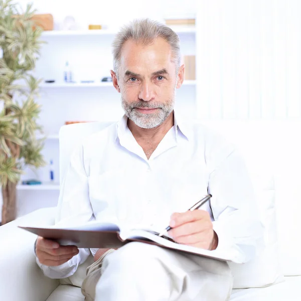 Businessman sitting on the couch and examines important documents — Stock Photo, Image