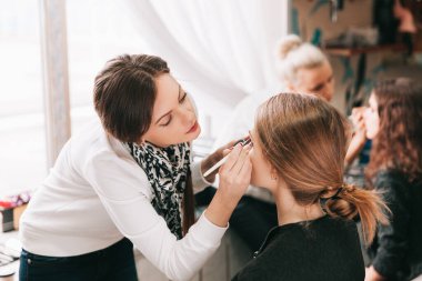 Bir güzellik salonunda sandalyede oturan genç bir kadın.