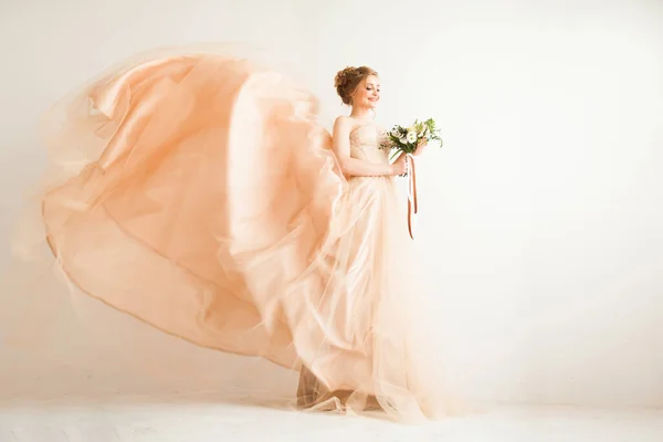 Bride with a bouquet in a beautiful wedding dress — Stockfoto