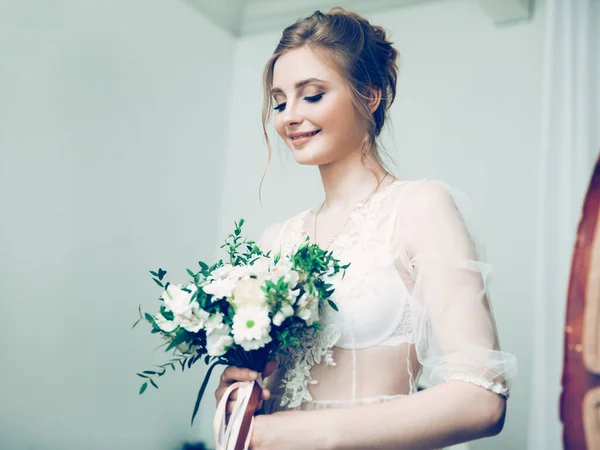 Retrato de uma noiva muito jovem com um buquê de casamento — Fotografia de Stock