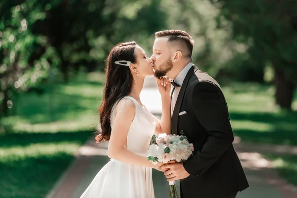 Loving couple of newlyweds standing on a Park alley — Stok fotoğraf