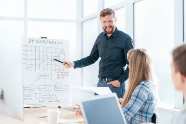 İş sunumu sırasında grafiğe işaret eden işadamı