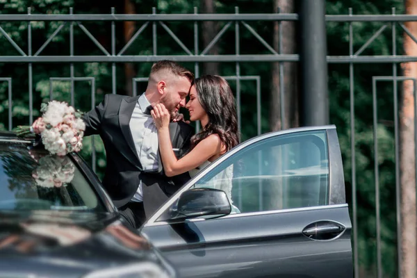Закрывай. невеста и жених стоят рядом с машиной — стоковое фото