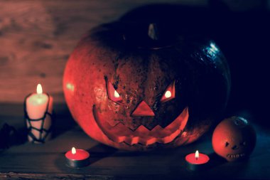 Mumlar, balkabakları ve tahta arka planda bir örümcek.