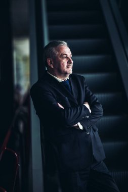 karanlık bir arka plan üzerinde modern bir ofis merdivenlerde durup başarılı iş adamı
