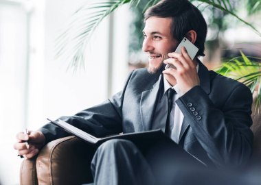 Ofis telefonu konuşurken kendinden emin iş adamı.