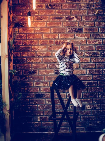 Retrato de una niña sobre un fondo de pared de ladrillo . —  Fotos de Stock