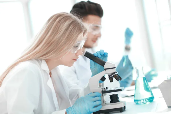 Cientista close up.woman realizando experimentos com líquido — Fotografia de Stock