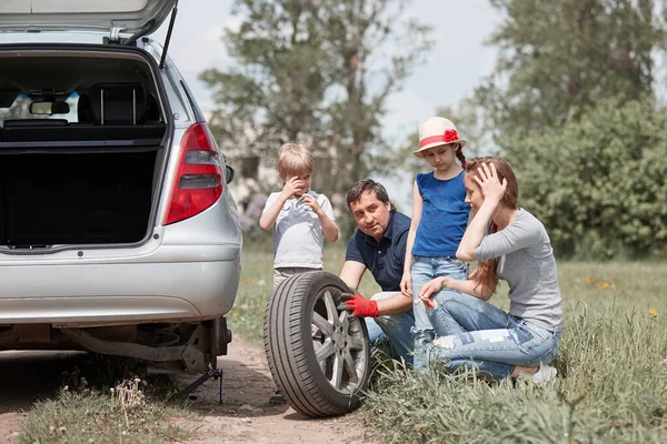 Семья с двумя детьми заменить шины семейного автомобиля . — стоковое фото