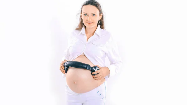 Mulher grávida feliz coloca fones de ouvido em sua barriga — Fotografia de Stock