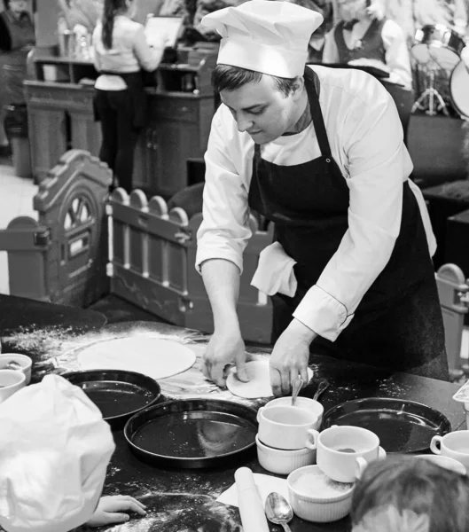 Chef muestra cómo amasar la masa para pizza . — Foto de Stock