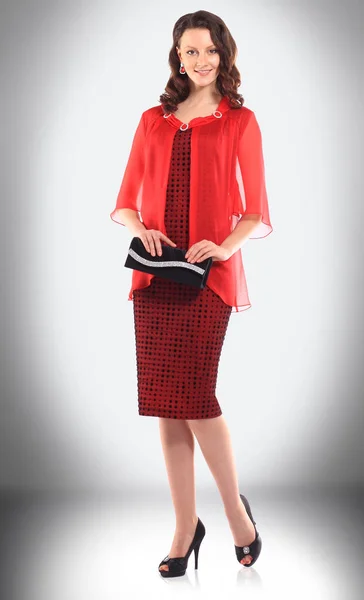 Atractiva mujer joven en vestido rojo y bolso de mano elegante negro — Foto de Stock