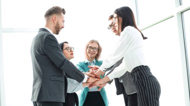İş adamları ofiste dikilirken birliklerini gösteriyorlar.