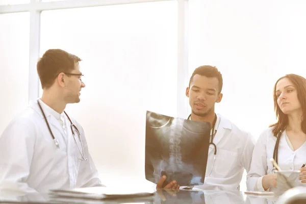 Lekarze Dyskutować rentgenowskie pacjent siedział przy stole — Zdjęcie stockowe