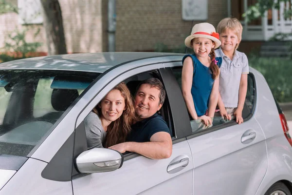 Νεαρή οικογένεια με τα παιδιά τους σε ένα οικογενειακό αυτοκίνητο. — Φωτογραφία Αρχείου