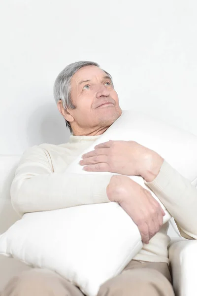 Ένας ηλικιωμένος άνδρας με ένα άνετο pillow.isolated σε λευκό — Φωτογραφία Αρχείου