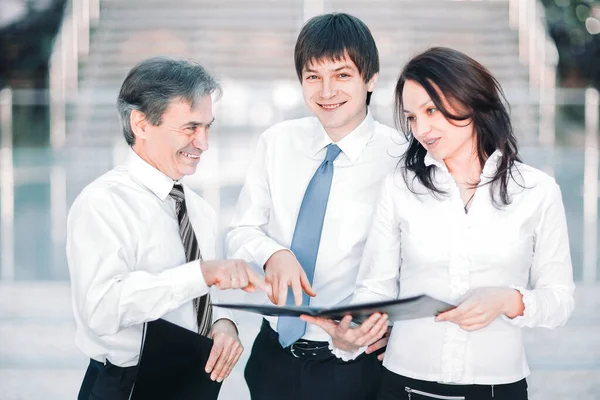 Business colleagues discussing working papers standing in a modern office — Stock Photo, Image