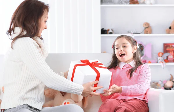 Mom gives her daughter a box with a birthday gift — Stock Photo, Image
