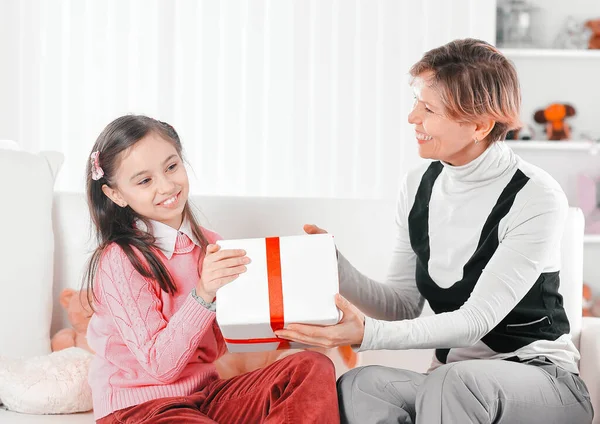 Grandmother gives granddaughter a box with a gift — Stock Photo, Image