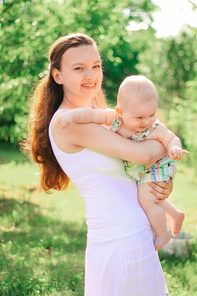 Lachende moeder en gelukkig een-jaar-oude dochter op een wandeling in het Park — Stockfoto