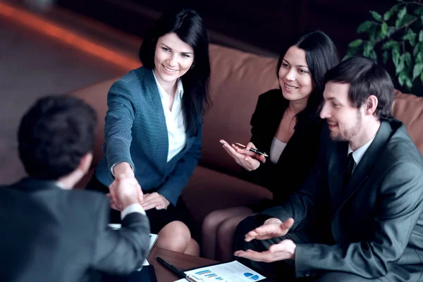Close up.business woman shaking hands with business partner sitting at work Desk — Stock Photo, Image