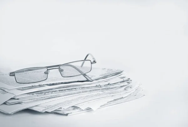 Pile de journaux et de lunettes isolés sur blanc — Photo