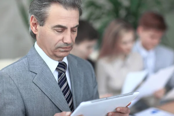 Close up. modern businessman looking at digital tablet screen.photo on blurred office background — Stock Photo, Image
