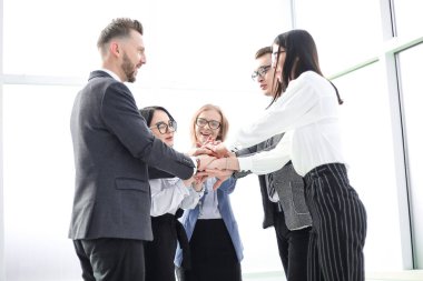İş adamları ofiste dikilirken birliklerini gösteriyorlar.