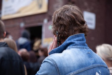 Adam şehir caddesinde cep telefonuyla konuşuyor.
