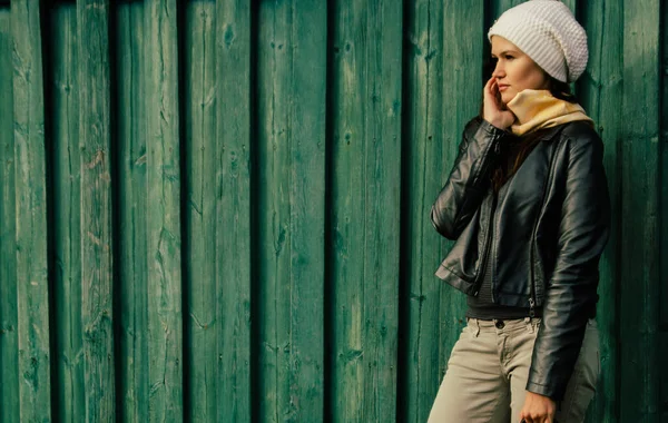 Serieuze jonge vrouw staan in de buurt van houten hek — Stockfoto