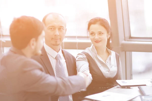 Smiling female and male business leaders handshaking over desk — Stock Photo, Image