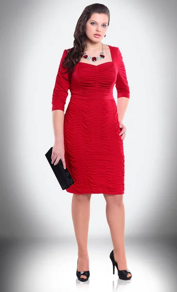 Elegancka młoda kobieta w czerwonej sukience i skórzanej torebce. — Zdjęcie stockowe