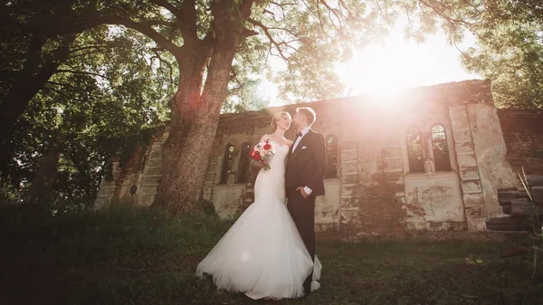 Vackra par nygifta stående nära en övergiven egendom — Stockfoto