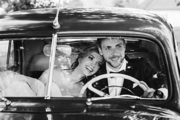 De près. jeunes mariés assis dans la voiture. noir et blanc photo — Photo