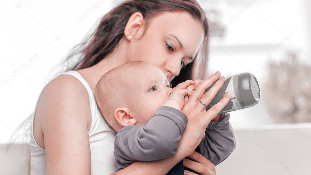 caring young mother feeds the baby. the concept of motherhood