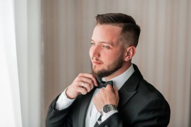 Kapat. Ceketini ilikleyen ciddi bir adam..