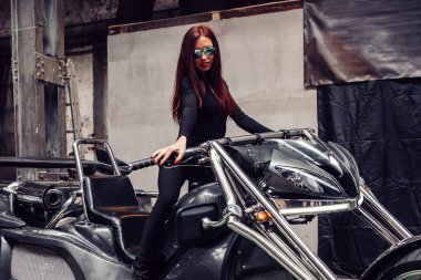 Şık bir üç tekerlekli bisikletin yanında duran şık genç kadın modeli..