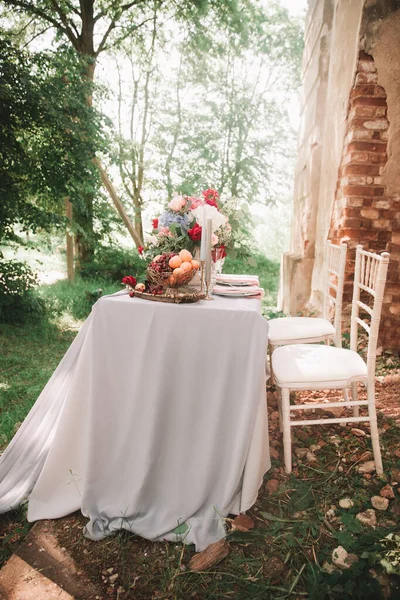 Mesa de boda decorada con velas en el jardín . — Foto de Stock