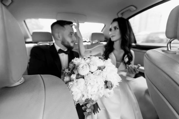 Κλείσε. Ευτυχισμένη νύφη και γαμπρός κάθονται σε ένα κομψό αυτοκίνητο. — Φωτογραφία Αρχείου