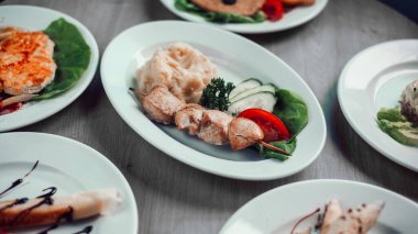 Sehpada patates püresi ve diğer tabaklar ile porsiyon kebap