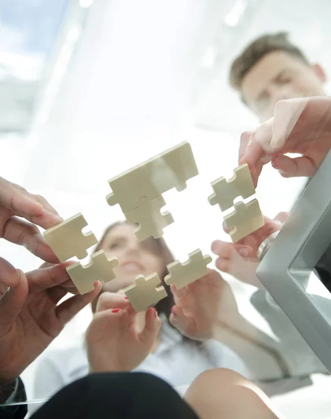 Bottom view. business team folding puzzle pieces. . — Stock Photo, Image