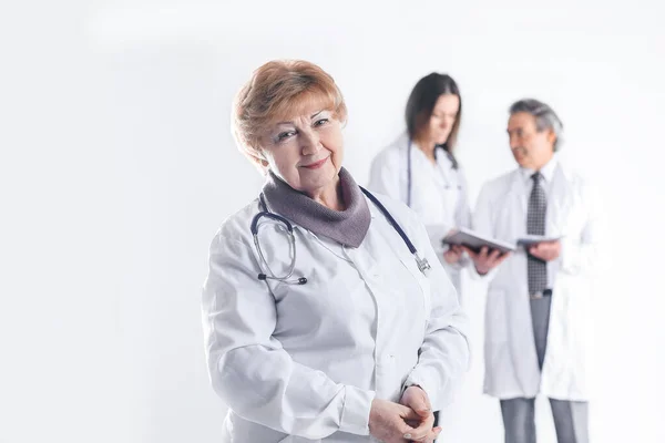 Adult female doctor therapist on blurred background of colleagues — Stock Photo, Image