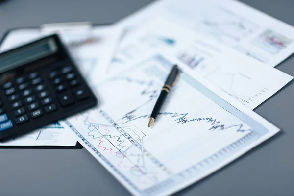 Close up.pen, gráfico financiero y calculadora en el escritorio —  Fotos de Stock
