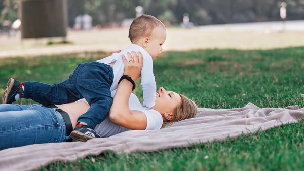 Maman avec son petit fils jouant sur la pelouse un jour d'été . — Photo