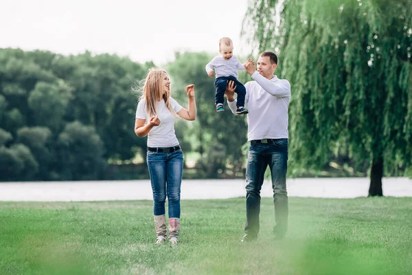 Happy parents with their little son walking together in spring Park — Stock Photo, Image