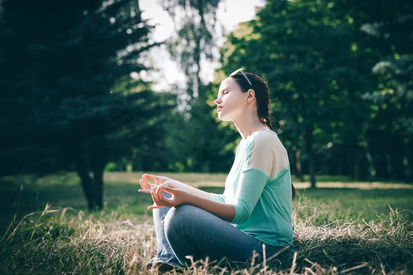 Lado view.beautiful mulher meditando na posição Lotus ao ar livre — Fotografia de Stock