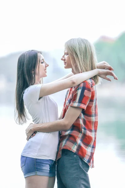 Jeunes amoureux debout sur le bord du lac — Photo